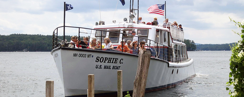 A boat with flags on top and people riding on deck