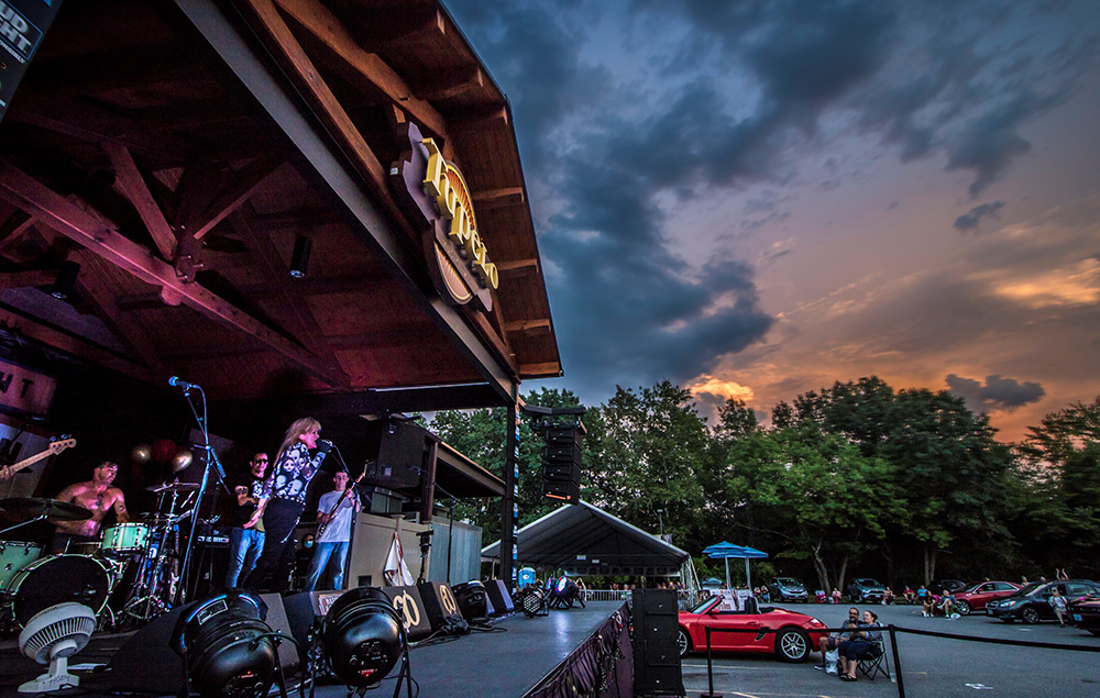 A band playing on an outdoor stage at sunset