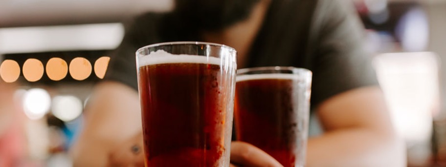 Image of a beer sitting on top of a bar at Millyard Brewery with a blurred background