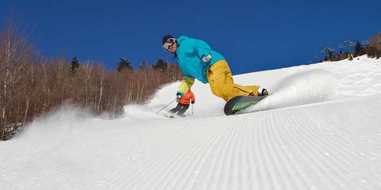 2 skiers skiing down a mountain at Waterville Valley Resort